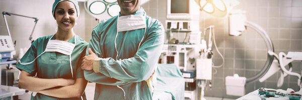 Portrait of surgeons standing while smiling at operation theater