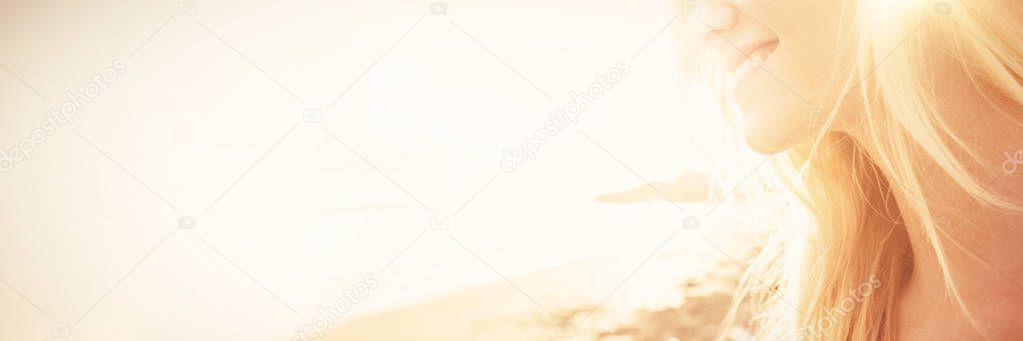 Smiling woman looking away at beach against sky