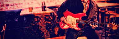 Genç adam barda gitar çalmak