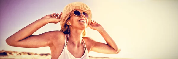 ビーチで晴れた日の間にサングラスと帽子を着て幸せな女 — ストック写真