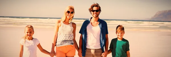 一緒にビーチで晴れた日の間に立ちながら手を取り合って幸せな家族の肖像画 — ストック写真