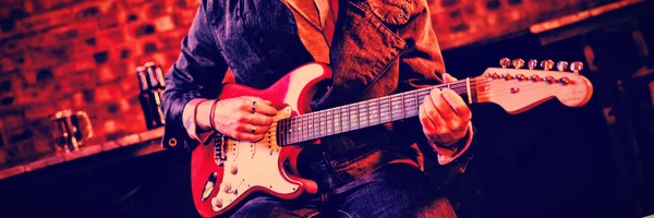 Genç adam barda gitar çalmak