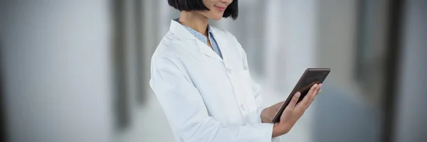 Arzt Mit Digitalem Tablet Vor Weißem Hintergrund Vor Leerem Krankenhausflur — Stockfoto