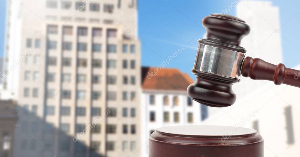 Digital composite of Gavel and city buildings auction