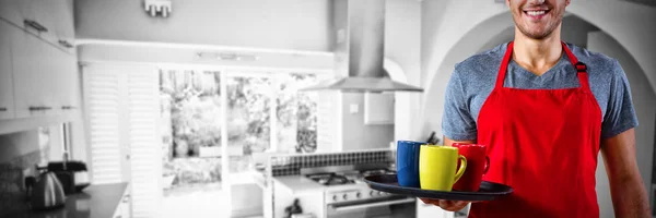 Αρσενικό Σερβιτόρος Κρατώντας Δίσκος Κούπα Καφέ Εναντίον Κουζίνα Ένα Καλαίσθητο — Φωτογραφία Αρχείου