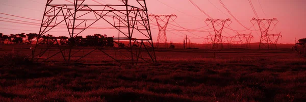 夜の電気のパイロン シルエット — ストック写真