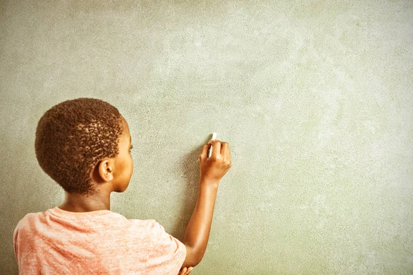 男孩在学校在 Greenboard 上用粉笔写的后视图 — 图库照片