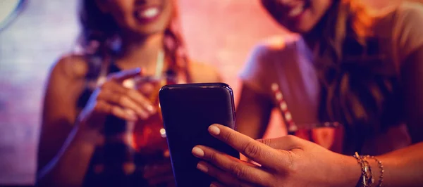 Dos Mujeres Jóvenes Usando Teléfono Móvil Pub —  Fotos de Stock
