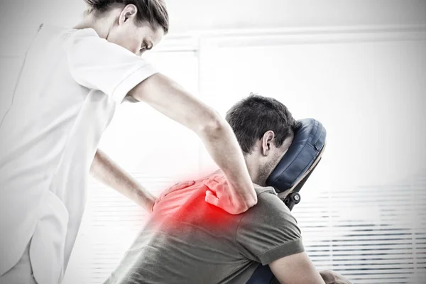 Physiotherapist giving back massage to man against highlighted pain