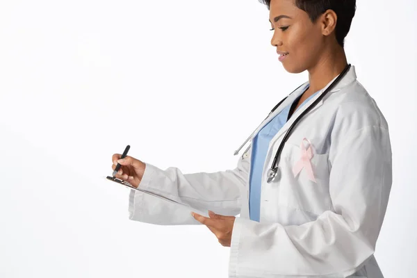 Female Doctor Wearing Breast Cancer Awareness Pink Ribbon Writing Note — Stock Photo, Image