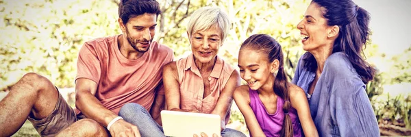 Família Sorrindo Olhando Para Tablet Digital Parque — Fotografia de Stock