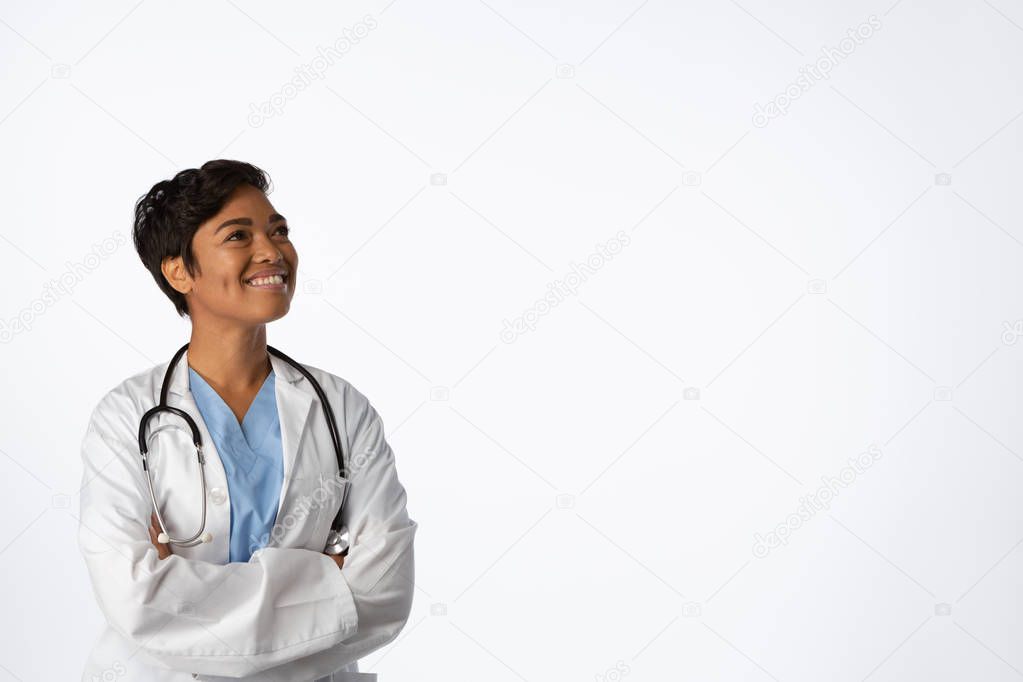 Smiling hopeful female doctor with crossed arms on a white background