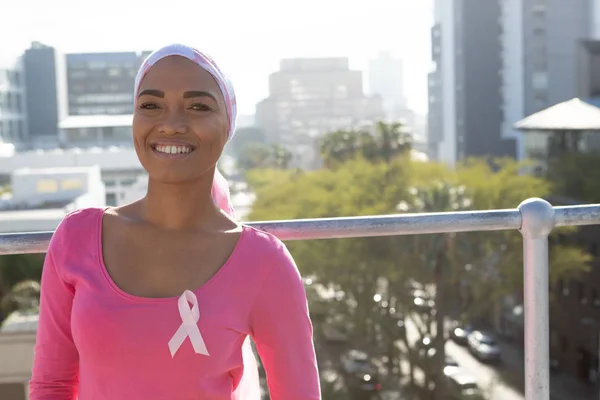Smiling woman with cancer over the city