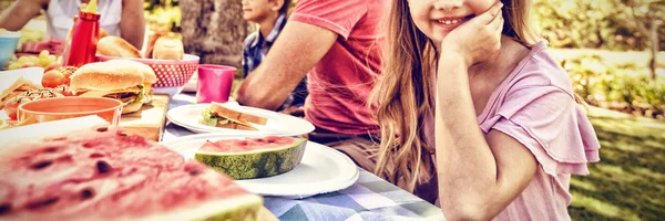 公園で彼女の家族の食事の Whith 持つテーブルに座っている少女の肖像画 — ストック写真