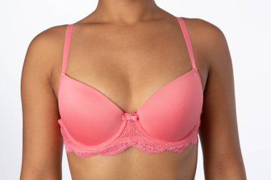 Pembe sütyen beyaz arka plan üzerinde izole kadın meme orta bölümünde