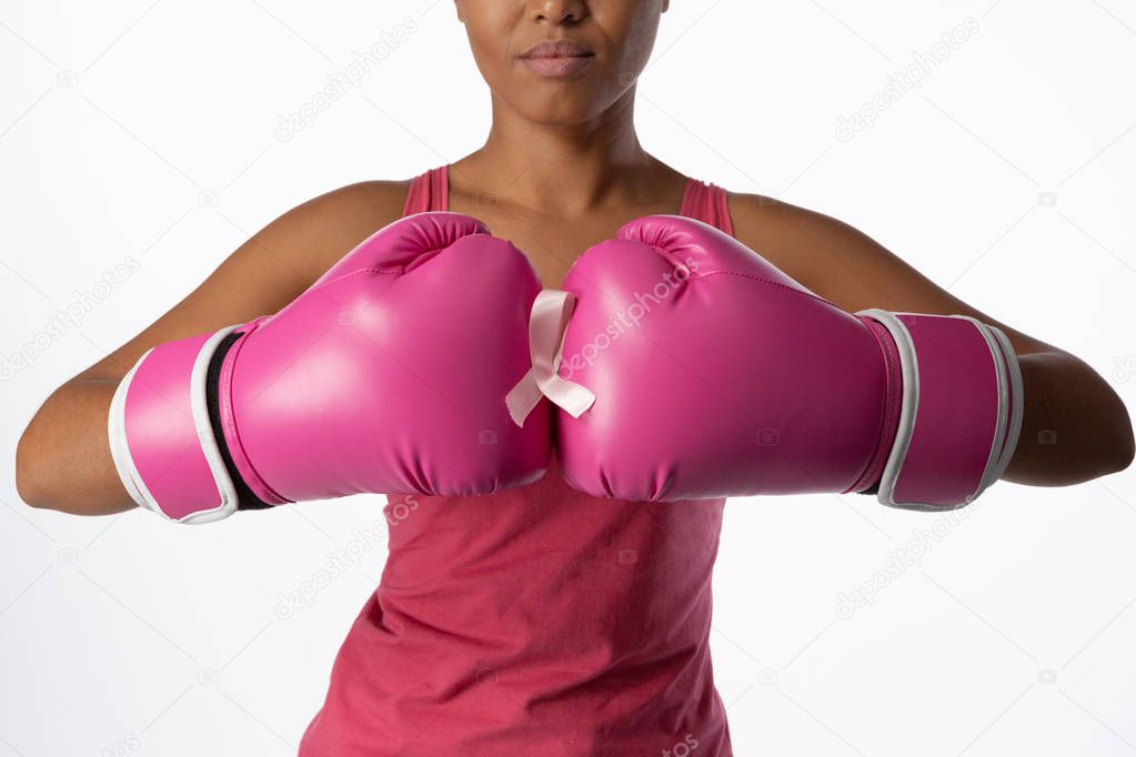 Standing woman for breast cancer awareness with ribbon and boxing gloves on white background