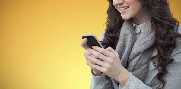 Sarı Arka Plana Karşı Akıllı Telefon Kullanan Kadın — Stok fotoğraf