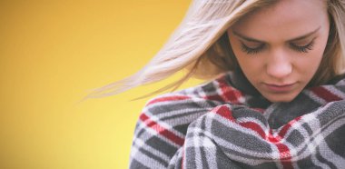 Sarı arka plan battaniye sarılı bir kadının yakın çekim