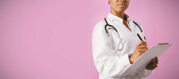 Formella Sjuksköterska Med Ett Rosa Band Som Skriver Ett Anteckningsblock — Stockfoto