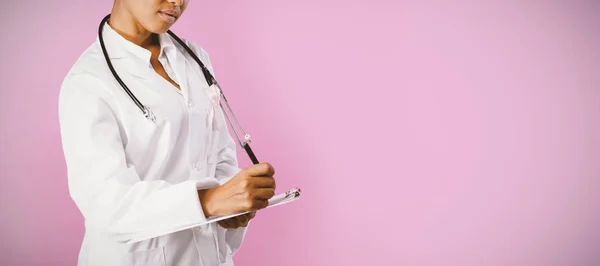 看護師乳がん意識ピンク リボンを身に着けているピンクの背景を書く — ストック写真