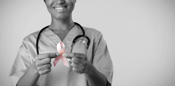 Leende Sjuksköterska Holding Breast Cancer Awareness Rosa Bandet Med Båda — Stockfoto