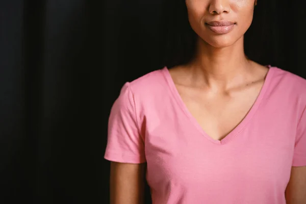 Vrouw Met Een Roze Shirt Reputatie Tegen Zwarte Achtergrond — Stockfoto