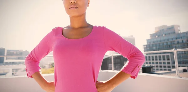 严肃的前瞻的女人站在粉红色的衬衫对城市背景的信心 — 图库照片