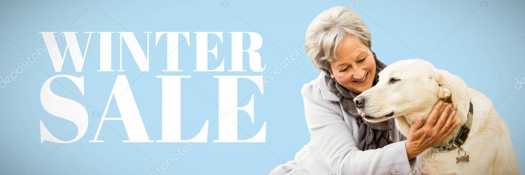 Senior woman holding a dog against blue winter sale background