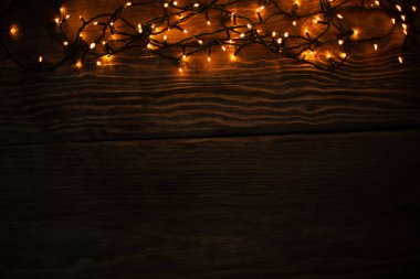 ahşap arka plan üzerinde Noel sarı elektrik garland ile kopya alanı