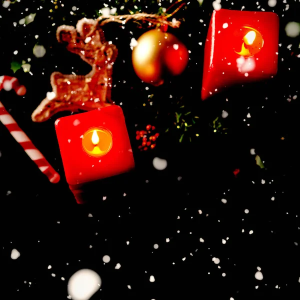 Sneeuw Vallen Tegen Twee Kerst Rode Vierkante Kaarsen — Stockfoto
