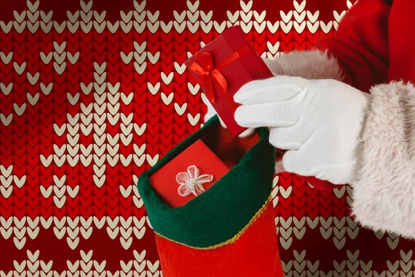 Santa Claus Βάζοντας Παρουσιάζει Χριστούγεννα Κάλτσες Εναντίον Κόκκινο Απρόσκοπτη Πλεκτό — Φωτογραφία Αρχείου