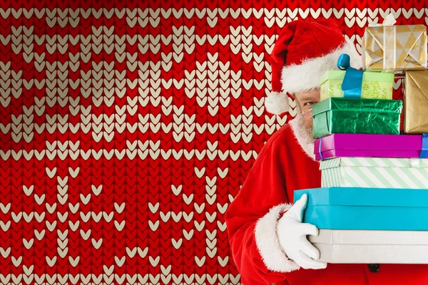Санта Клаус Прячется Стопкой Рождественских Подарков Против Красного Бесшовного Трикотажа — стоковое фото