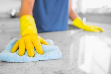 Woman cleaning the counter in the kitchen clipart