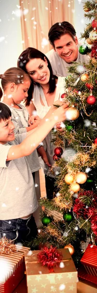 Família Feliz Decorando Uma Árvore Natal Com Bugigangas Contra Queda — Fotografia de Stock