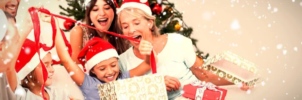 雪に対して贈り物を一緒に開くクリスマスで幸せな家族 — ストック写真
