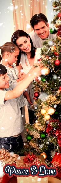 Šťastná Rodina Zdobení Vánočního Stromu Ozdoby Proti Mírové Poselství — Stock fotografie