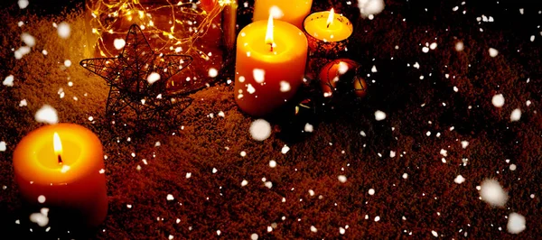 雪花落在圣诞蜡烛和装饰品上 — 图库照片