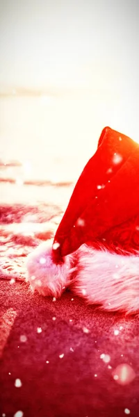雪对圣诞老人的帽子落在沙滩上 — 图库照片