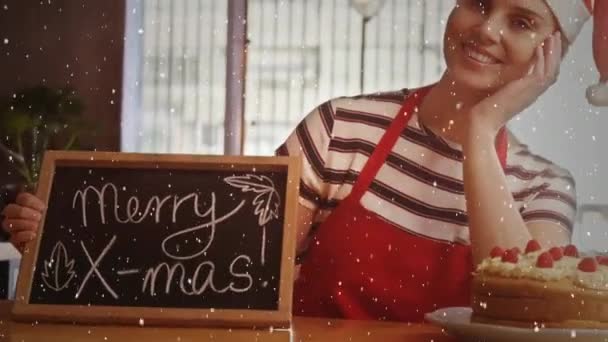 录影构成与下落的雪在愉快的女孩在圣诞老人帽子与黑板在商店 — 图库视频影像
