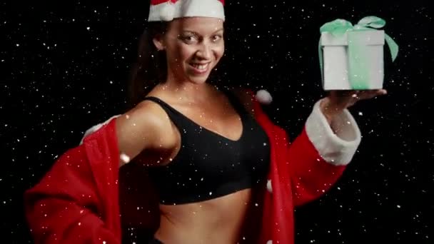 视频组成与降雪在快乐的女孩在圣诞老人西装 同时举行礼品盒 — 图库视频影像