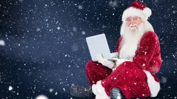 Digitální složený Santa Clause sedí před jeho notebookem, v kombinaci s padajícím sněhem