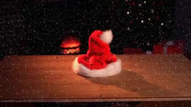 Video Sammansättning Med Fallande Snö Över Skrivbord Med Santas Hatt — Stockvideo