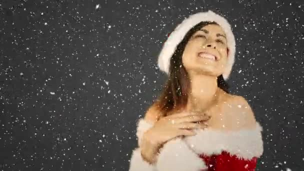 サンタ スーツ オープン手のひらを示す幸せな女の子で雪が降っていると映像の合成 — ストック動画