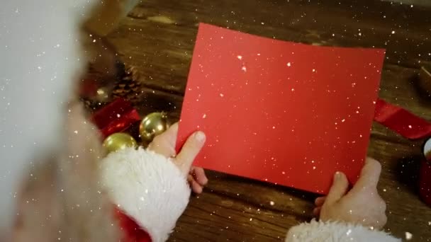 Відео Композиція Падаючим Снігом Над Столом Сантою Тримає Червону Картку — стокове відео