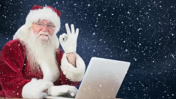 Cyfrowy Kompozytowy Santa Klauzuli Siedząc Swoim Laptopie Połączeniu Padającego Śniegu — Wideo stockowe