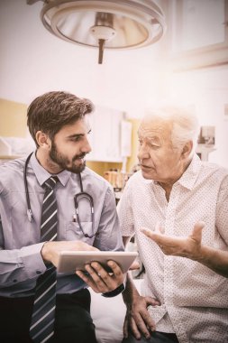 Doktor hasta ile hastane dijital tablet üzerinde tartışıyor
