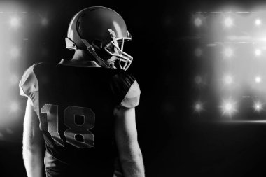 Rugby kask siyah arka plan ile ayakta Amerikan futbolu oyuncusu