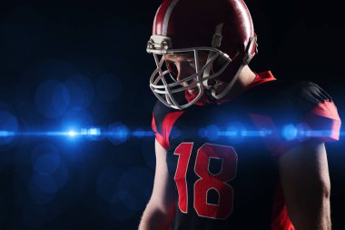 Kask ayakta siyah arka plan karşı düşünceli Amerikan futbolu oyuncusu