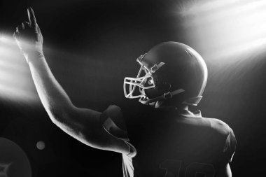 Arkadan Görünüş kask yukarı doğru işaret içinde Amerikan futbolu oyuncusu