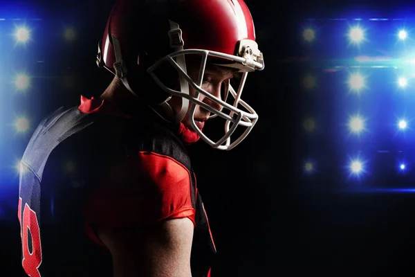 戴头盔的美国足球运动员站在黑色背景下 — 图库照片